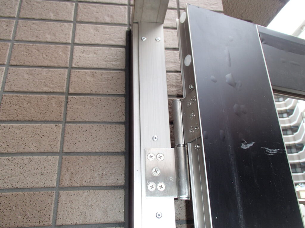 フラットバーに位置出しを行い、丁番を取り付けて行きます。<br />
ここで注意は、扉の開け閉めの時に、<br />
かなり丁番位置に負荷がかかるので、<br />
バーが動かない様に確認が大事です。